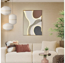 Ljust vardagsrum med beige soffa, abstrakt väggkonst med belysning, randiga taklampor och krukväxter.