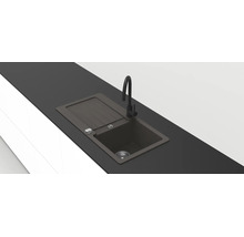Modern svart inbyggnadsvask i komposit med avrinningsyta och hög svart blandare i en mörk bänkskiva.