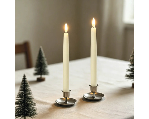 Två LED-stavljus i metallhållare på ett bord med små dekorativa granar.