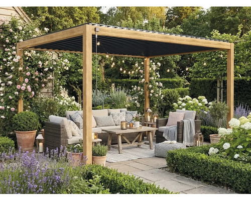 Träpergola med svart lamelltak på en terrass. Med loungemöbler i rotting, träbord och trädgårdsväxter som lavendel och rosor.