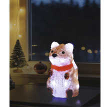 Belyst akrylfigur ekorre med röd halsduk på ett bord, juldekoration för inomhusbruk med julgran i bakgrunden.