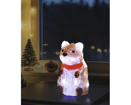 Belyst akrylfigur ekorre med röd halsduk på ett bord, juldekoration för inomhusbruk med julgran i bakgrunden.