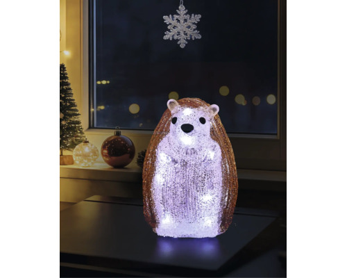 LED-dekorationsfigur igelkott av akryl med en kristalliknande yta, stående på ett bord i ett festligt dekorerat rum med juldekorationer.