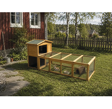 Kaninbur i trä med integrerad utegård och trådnät på en gräsmatta i en trädgård.