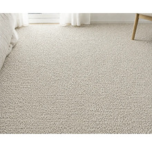 Strukturerad heltäckningsmatta i bouclé-stil i ett ljust rum med säng, gardin och stolsben.