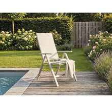 Modern hopfällbar trädgårdsstol med högt ryggstöd på en träaltan vid en pool, omgiven av en grönskande trädgård med blommor.