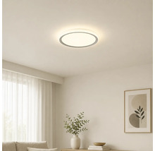 Rund LED-taklampa i ett ljust, modernt inrett vardagsrum med minimalistisk design.