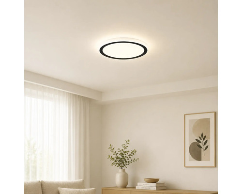 Modern rund LED-taklampa med svart kant i ett ljust, minimalistiskt vardagsrum med vita väggar och ljusa möbler.