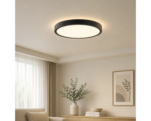 Modern rund LED-taklampa med svart ram i ett ljust vardagsrum.