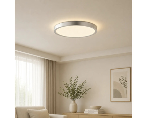 Rund LED-taklampa med metallram, monterad i ett ljust tak i ett modernt inrett vardagsrum.
