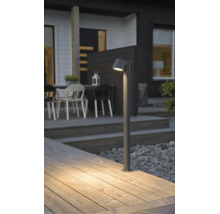 Modern pollare på en träterrass framför ett hus, varmvitt ljus lyser på trätrallen.