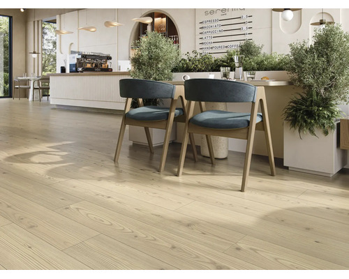 Ljust laminatgolv i trädekor i ett modernt inrett café med sittgrupp och växter.