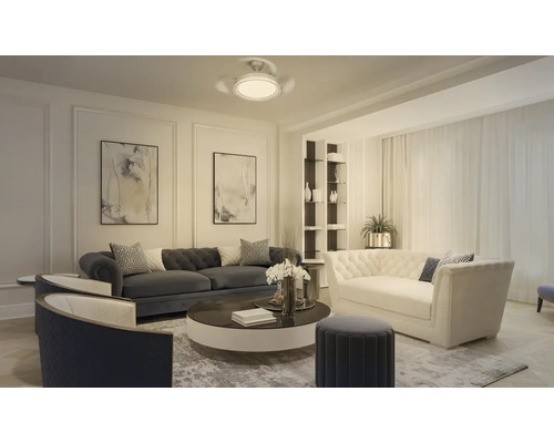 Modernt, rymligt vardagsrum med Chesterfield-soffor, fåtöljer, ett runt soffbord, abstrakt väggkonst och en takfläkt med lampa.