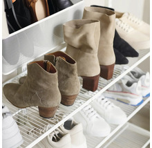 Organiserat skoställ i metall med gallerhyllor, fyllt med olika ankelboots och sneakers för en överskådlig förvaring.