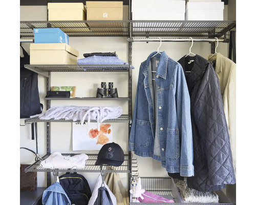 Modulärt hyllsystem i metall med gallerhyllor, klädstång och Adidas Logo på en låda, organiserat med kläder och accessoarer.
