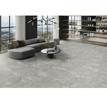 Modernt vardagsrum med stora grå golvplattor i granitkeramik med betonglook, grå soffa och stora fönster.