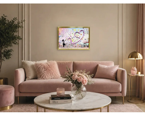 Modernt vardagsrum med rosa sammetssoffa, soffbord i marmor och en inramad tavla föreställande en flicka med ett hjärta av fjärilar.