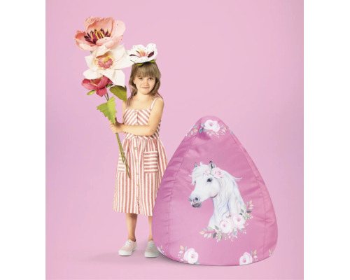 Barn bredvid en sittsäck med hästmotiv och blommönster.