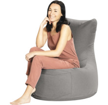 En kvinna som sitter i en grå sittsäck med högt ryggstöd av textil.