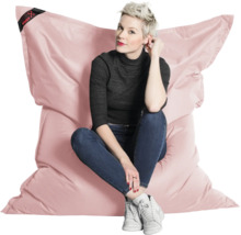 Stor rosa sittsäck med en person som sitter på den. Bekväm sittkudde för inomhusbruk.