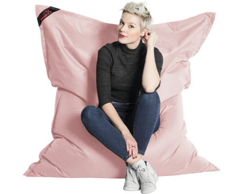 Stor rosa sittsäck med en person som sitter på den. Bekväm sittkudde för inomhusbruk.