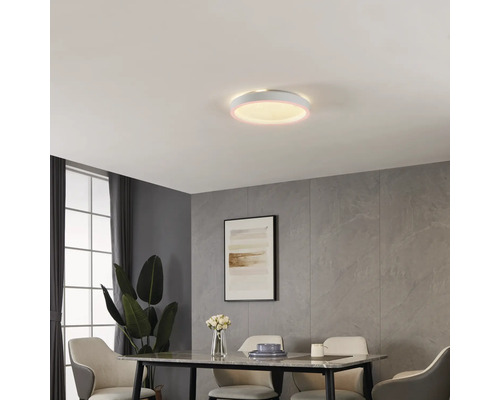 Rund LED-taklampa i modernt matsal med väggpaneler i stenlook, matbord och klädda stolar. Lampan har en lysande kant.