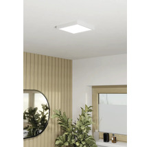 Fyrkantig LED-panel som taklampa i ett modernt inrett rum med ribbvägg i trä, spegel och inomhusväxt.