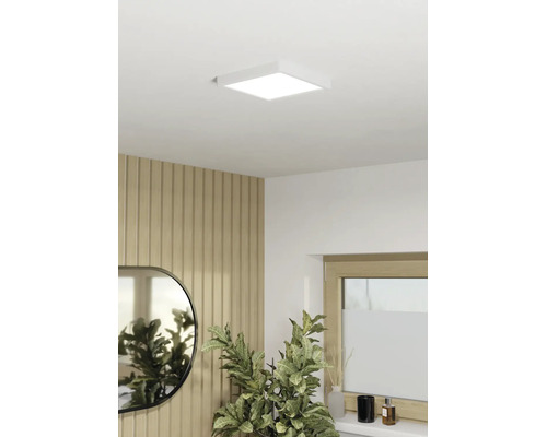 Fyrkantig LED-panel som taklampa i ett modernt inrett rum med ribbvägg i trä, spegel och inomhusväxt.