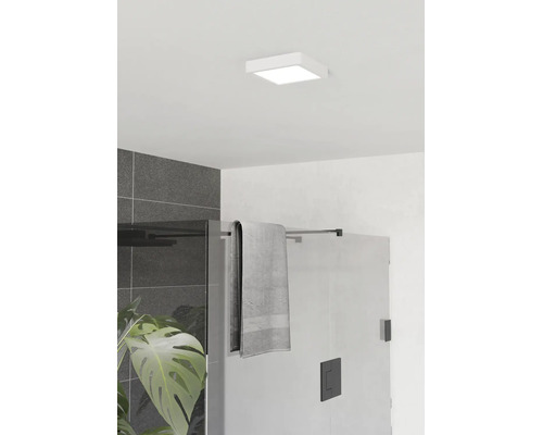 Kvadratisk LED-taklampa i ett modernt badrum ovanför en duschvägg i glas med svarta beslag och mörkgrått väggkakel.