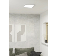 Kvadratisk LED-takpanel i ett modernt vardagsrum med grå vägg och minimalistisk dekoration.