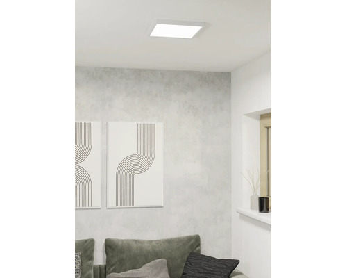 Kvadratisk LED-takpanel i ett modernt vardagsrum med grå vägg och minimalistisk dekoration.
