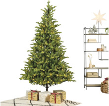 Konstgjord julgran med varmvit LED-belysning, julklappar och en modern metallhylla med juldekorationer på en matta.