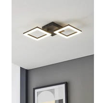Modern LED-taklampa med två fyrkantiga svarta ramar, monterad i ett vitt tak ovanför en grå vägg med en inramad tavla.