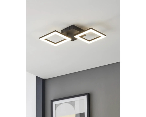 Modern LED-taklampa med två fyrkantiga svarta ramar, monterad i ett vitt tak ovanför en grå vägg med en inramad tavla.