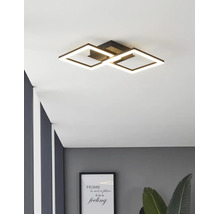 Modern svart LED-taklampa med två sammanflätade kvadratiska ljusramar i ett modernt inrett rum.