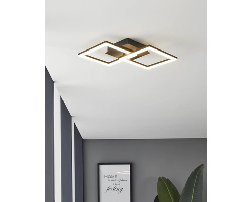 Modern svart LED-taklampa med två sammanflätade kvadratiska ljusramar i ett modernt inrett rum.