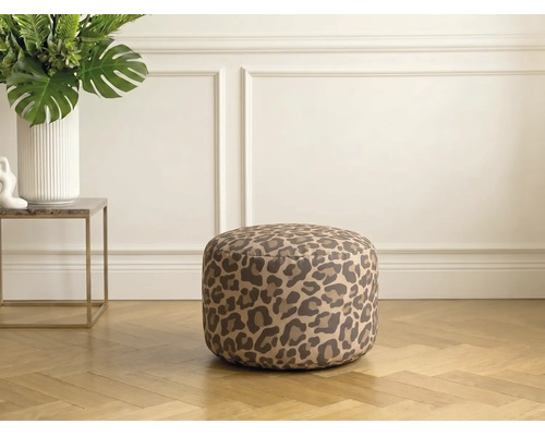 Rund sittpuff med leopardmönster i ett ljust vardagsrum på fiskbensparkett.