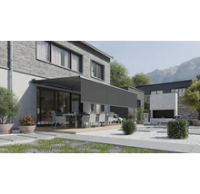 Modern terrassmarkis med utdragbar volang på ett hus med tegelvägg och trädgård med sittgrupp.