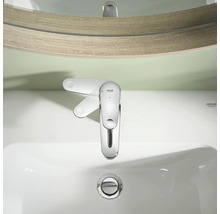 Grohe ettgrepps tvättställsblandare sedd uppifrån på ett vitt keramiskt tvättställ framför en spegel.