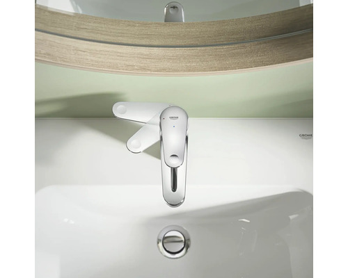 Grohe ettgrepps tvättställsblandare sedd uppifrån på ett vitt keramiskt tvättställ framför en spegel.