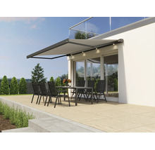 Modern terrassmarkis med inbyggd LED belysning över en sittgrupp på en terrass framför ett modernt hus.