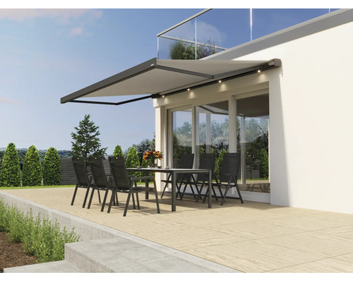 Modern terrassmarkis med inbyggd LED belysning över en sittgrupp på en terrass framför ett modernt hus.