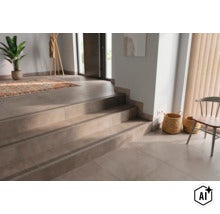Hall med kaklade trappsteg utrustade med trappnosprofiler i en modern hemmiljö med dekorativa föremål. (Image AI modified or generated)