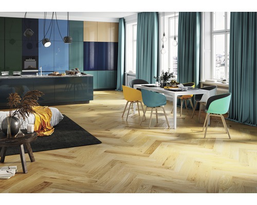 Ljust kök med trägolv, matbord och färgstarka skåp