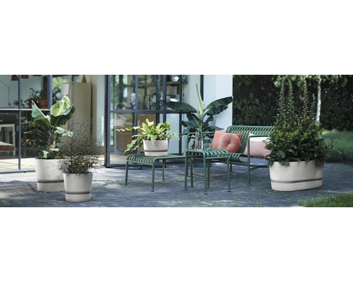 Utomhusområde med växter i planteringskärl, sittplatser och dekorativa element för en terrass eller trädgård