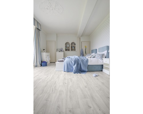 Ljust sovrum med säng och trägolv