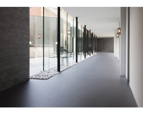 Lång korridor med glasvägg mot innergård och golvbeläggning