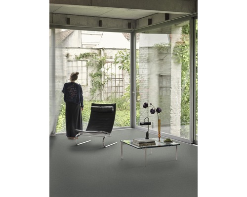 Ljust rum med stort fönster, fåtölj och soffbord på ett golv