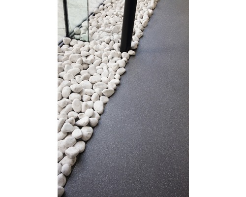 Dekorativa vita småstenar bredvid grått golv