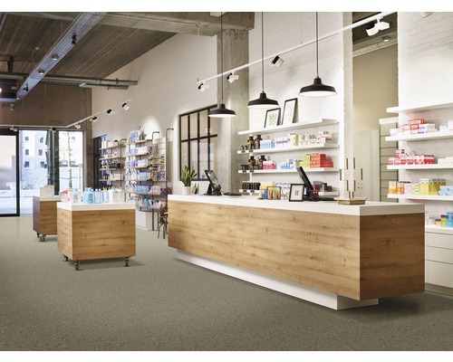 Interiör av ett ljust apotek med försäljningsdisk, hyllor och produkter